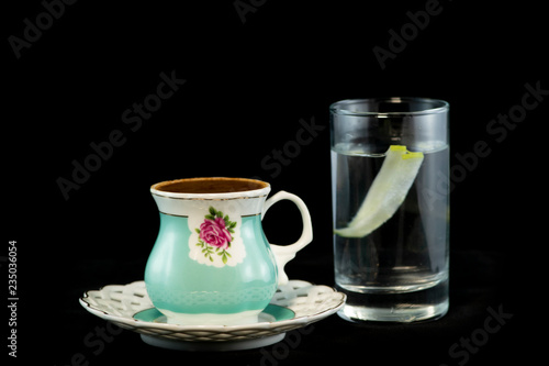 Turkish coffee and glass of water with isolated black background