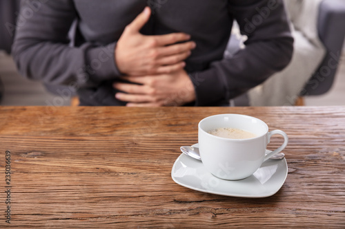 Cup Of Coffee In Front Of Man Having Stomach Pain