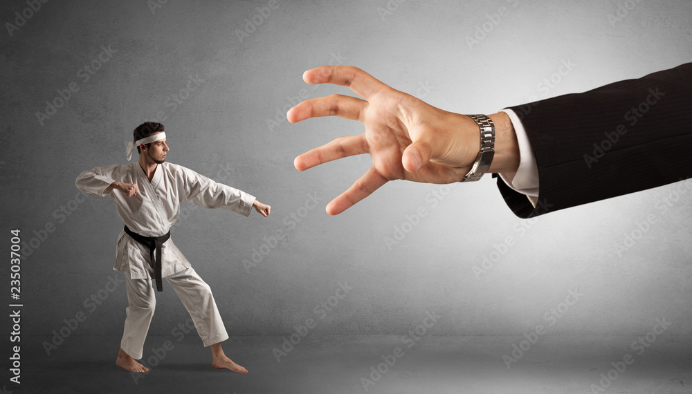 Small karate man fighting with big hand Small karate man fighting with big hand