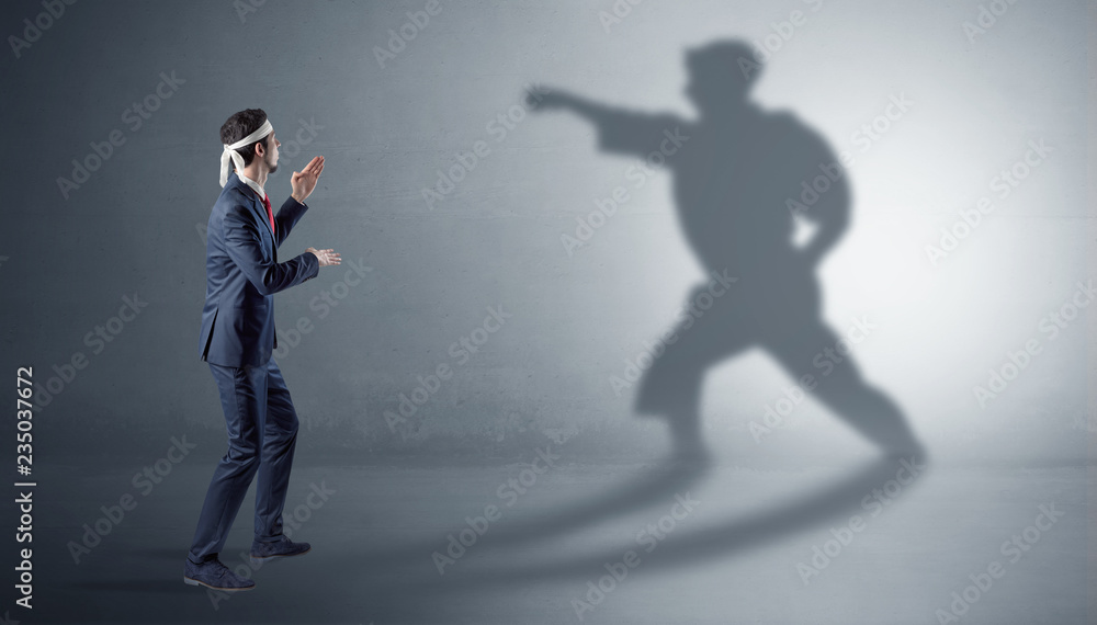 Businessman fighting with his strong karate man shadow
Businessman fighting with his strong karate man shadow