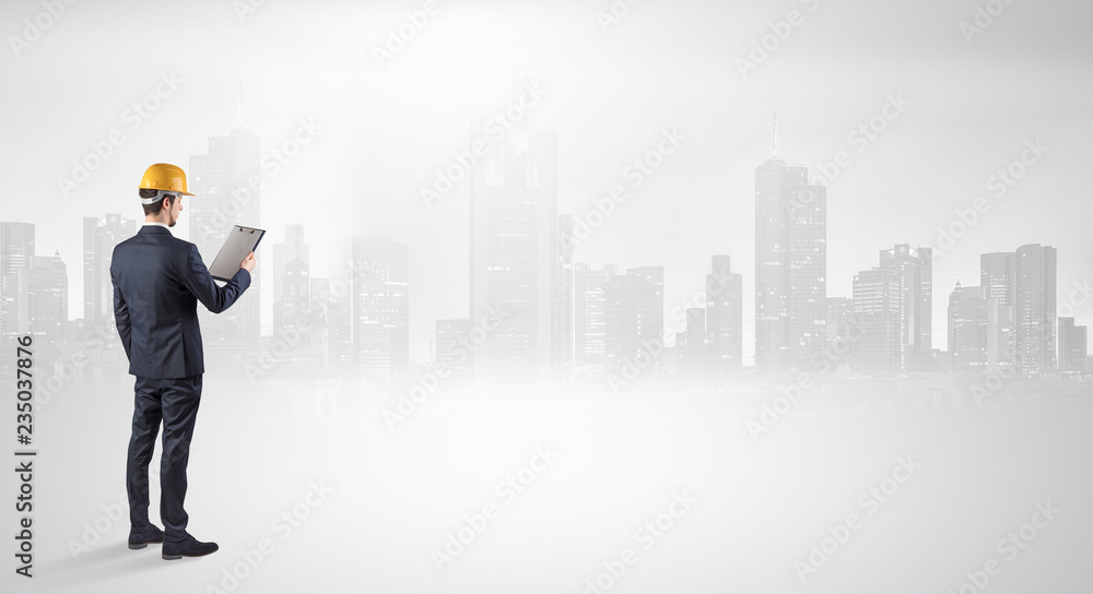 Young supervisor architect standing and looking at a big city panorama
Young supervisor architect standing and looking at a big city panorama