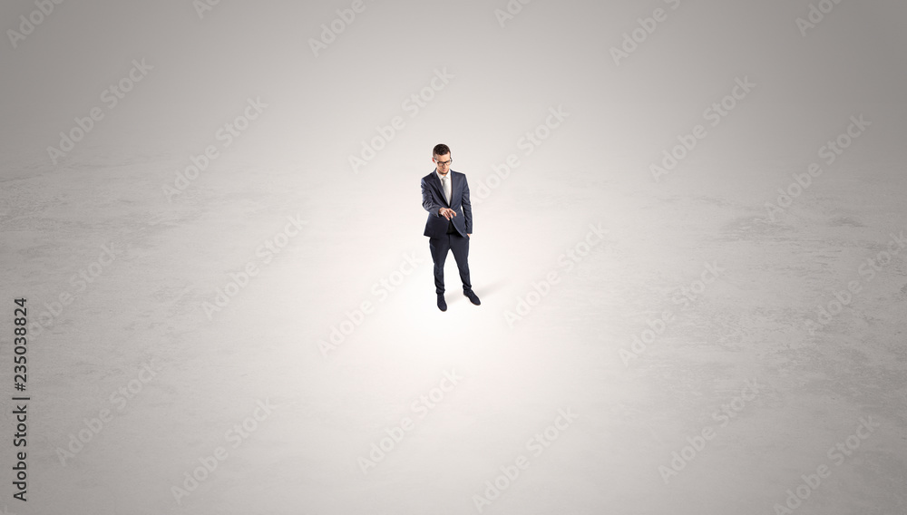 Young businessman standing alone in the middle of an empty space
Young businessman standing alone in the middle of an empty space