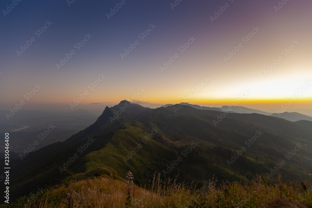 Mountains with spotted sunset at Doi Pha Tang, Chiang Rai, Thailand.