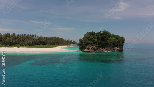 Drone flying away a rock formation on the small Island of Pulau Mincau near Simeulue Island, located off the coast of North Sumatra in Indonesia. photo