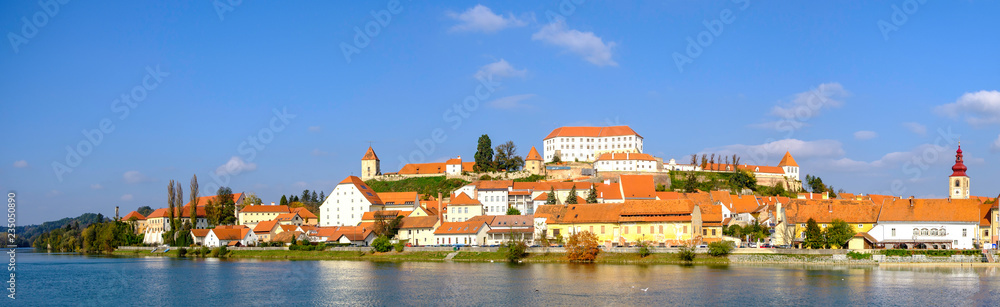 Scenic panoramic view of river Drava and castle on hill in old historic touristic town Ptuj in Slovenia