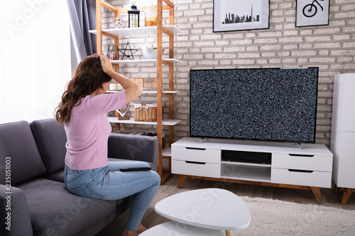 Frustrated Woman Looking At Television With No Signal