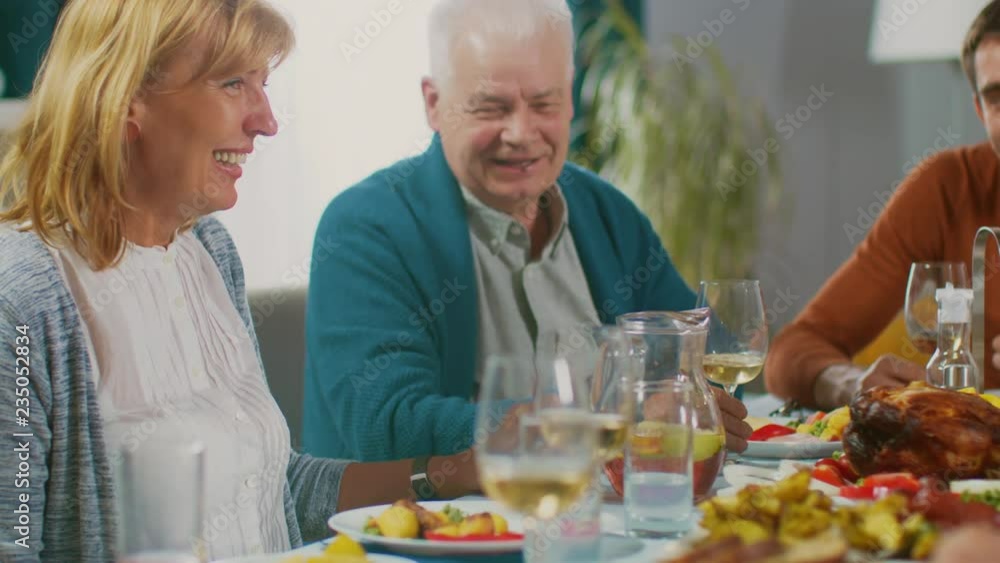 Family and Friends Gathering at the Dining Table. Senior Couple Talking, Joking and Eating. Family and Friends Gathering at the Dining Table. Senior Couple Talking, Joking and Eating.