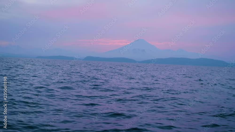 Pink sunset in mountain landscape on horizon and evening sea waves Pink sunset in mountain landscape on horizon and evening sea waves