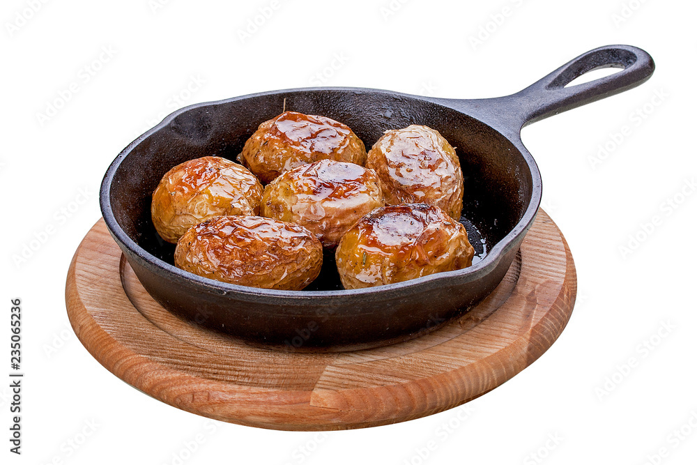 Baked whole potatoes in the pan. On a white background. Baked whole potatoes in the pan. On a white background.
