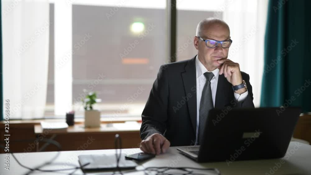 Happy Senior Businessman Using Phone And Laptop At Work Happy Senior Businessman Using Phone And Laptop At Work