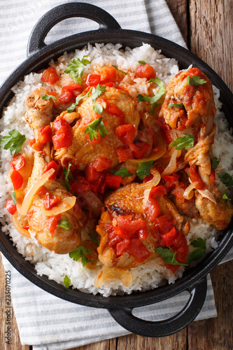 Haitian Chicken Recipe is a one pot of chicken, tomatoes, wine, spices, and rice close-up. Vertical top view