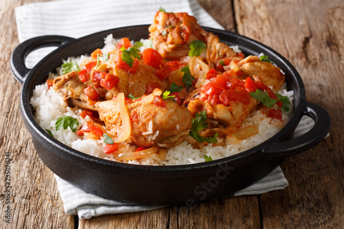 Haitian Stewed Chicken (Poule en Sauce)served with white rice in a black pan closeup. Horizontal