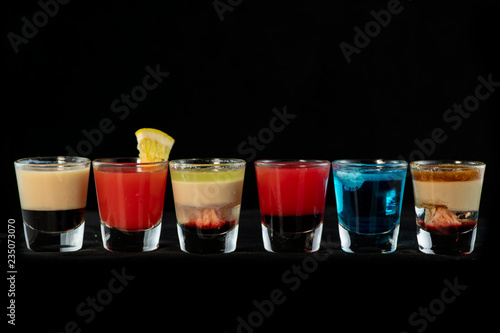 Mix alcoholic cocktail shots together with isolated black background