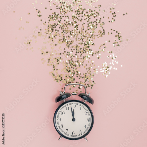 New Year concept. Alarm clock with golden confetti