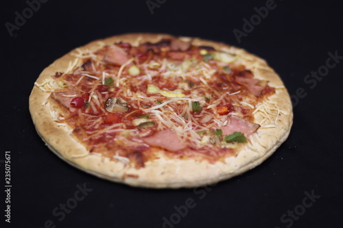 pizza with ham and cheese isolated on black