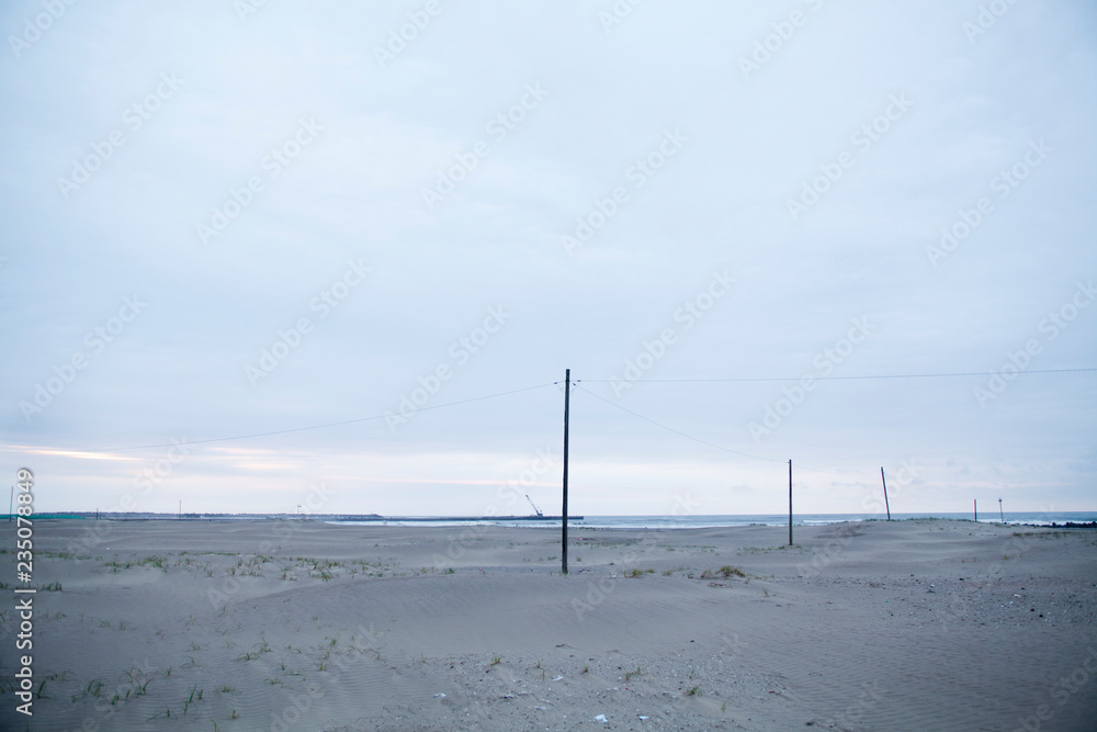 砂浜に立つ電柱