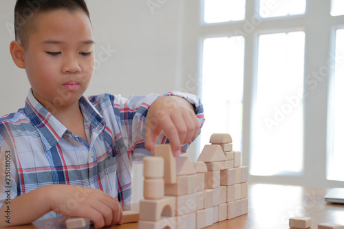 Fotografie little asian kid boy child children schoolboy playing wood block toy