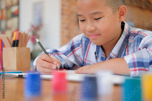 asian kid boy child schoolboy drawing picture. children activity at home