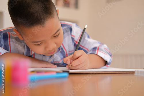 asian kid boy child schoolboy drawing picture. children activity at home