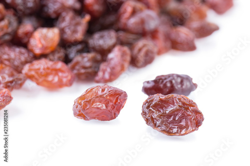 Black raisins close-up isolated on a white background. Angle view