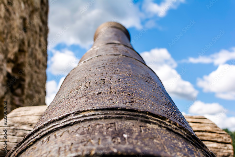 Old cannon muzzle pointed to the blue sky at Koknese Castle - one of the largest and most significant medieval castles on Latvian territory.