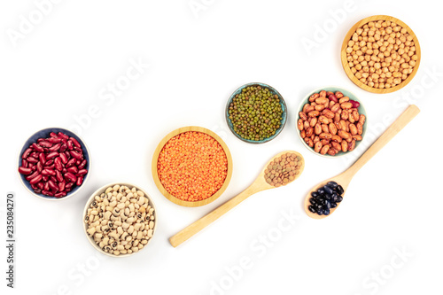 Various types of legumes, shot from above on a white background with copy space. Red kidney beans, lentils, chickpeas, soybeans, black eyed peas