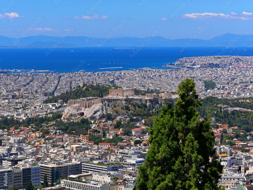 Greece, Athens panoramic view with parthenon temple on acropolis hill, Plaka old neighborhood and Saronic golf on the distant background