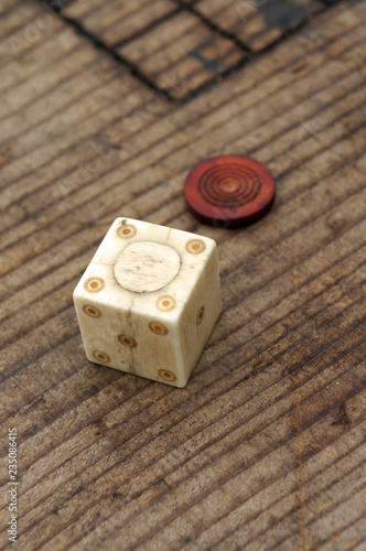 A copy of a Roman bone dice and a gaming counter.