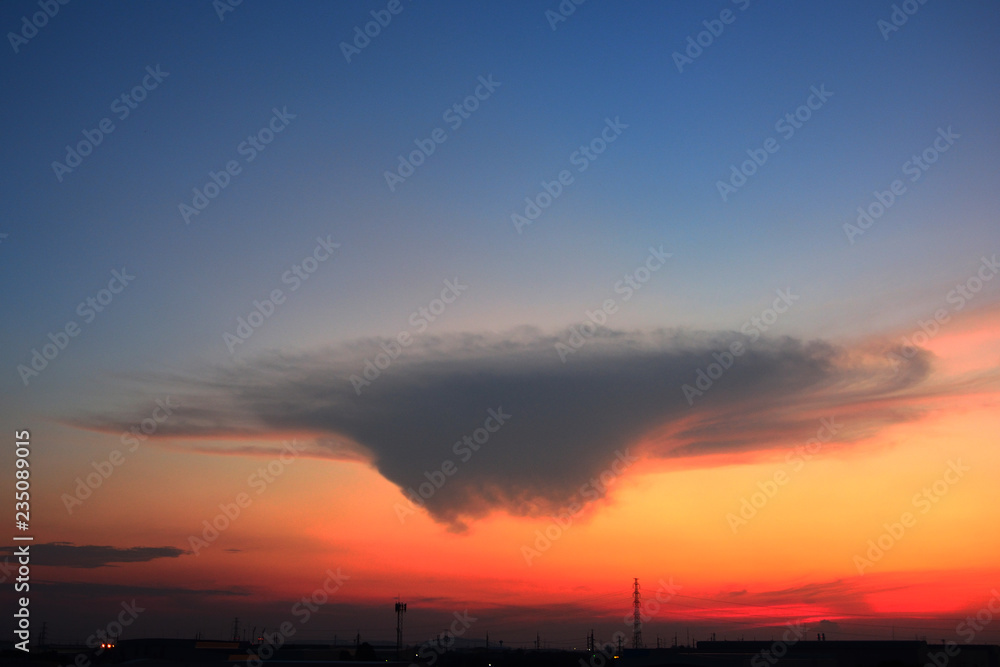 A strange cloud shape on blue sky background with sunrise