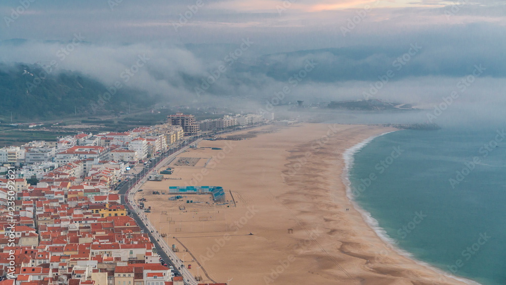 View of Nazare panorama with cabins of Funicular timelapse. Fog coming from ocean at evening during sunset.