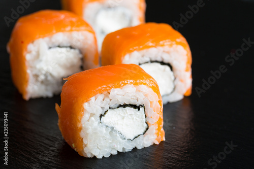A variety of sushi and rolls on a dark background