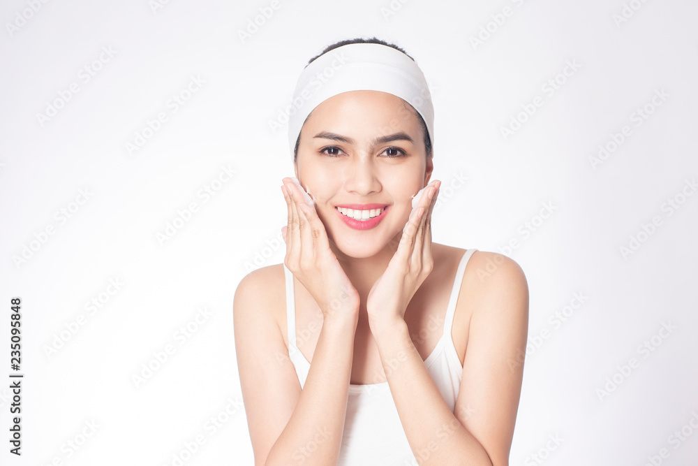 Beautiful woman is washing her face on white background Beautiful woman is washing her face on white background