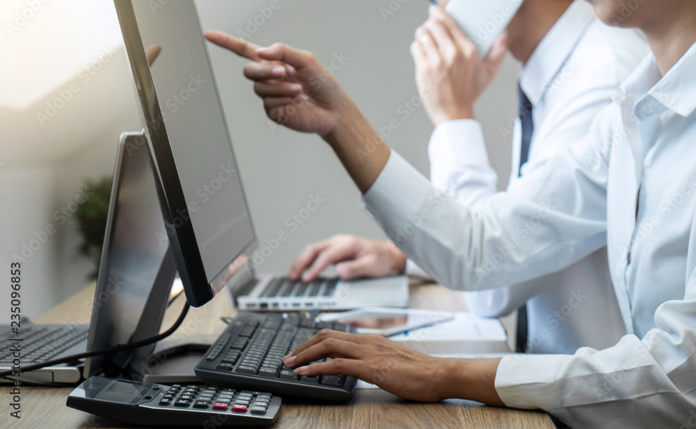 Stock exchange market concept, Team of investment trading or stock brokers having a consultation and analyzing with display screen and pointing on the data presented and deal on a stock exchange Stock exchange market concept, Team of investment trading or stock brokers having a consultation and analyzing with display screen and pointing on the data presented and deal on a stock exchange