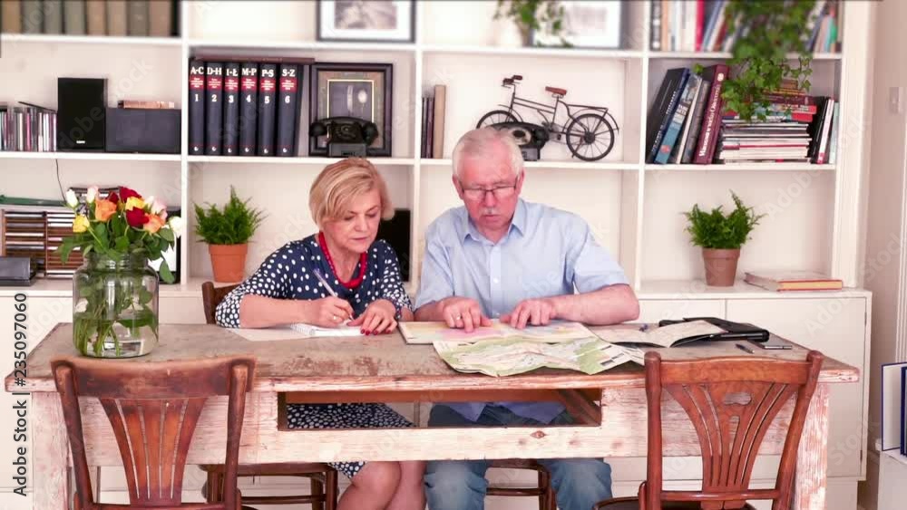 senior couple planning next holiday over map at home
senior couple planning next holiday over map at home