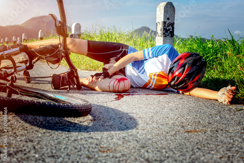 Foto woman cycling in hurt and injuried of leg after accident clashed, with mortal wound and bleeding of blood flow on the surface of street road