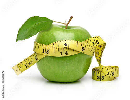 Whole green apple with measuring tape isolated on white background