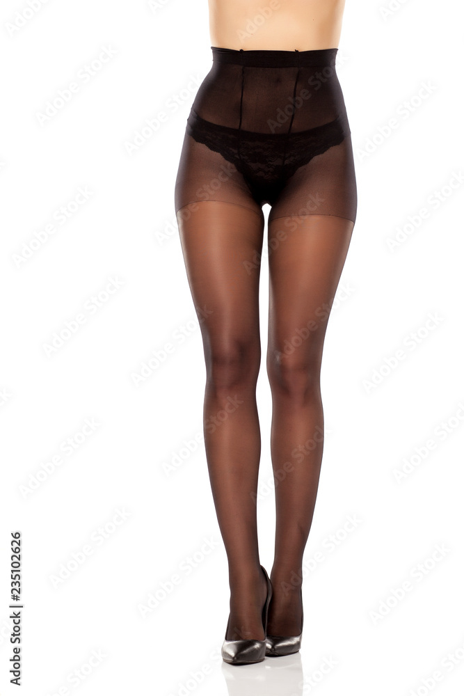 pretty female long legs, high heels and black high waist nylon stockings on white background