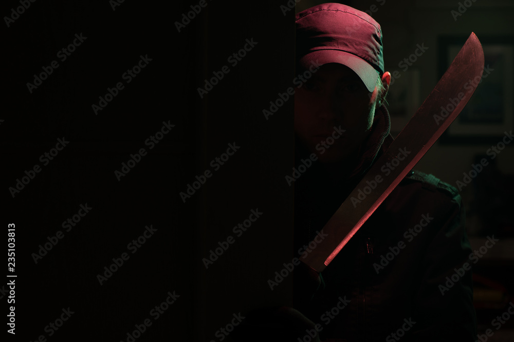 Image of killer with machete in dark apartment with red light - obrazy, fototapety, plakaty 