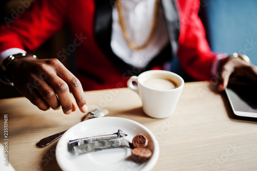 Hands of fashion african american man model at red suit, sitting at cafe with coffee. © AS Photo Family