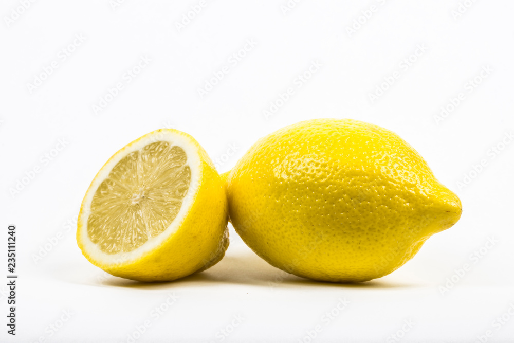 A whole lemon and a lemon cut in half. isolated in white with copy space. A whole lemon and a lemon cut in half. isolated in white with copy space.