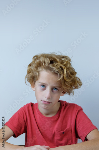 portrait of a blond boy with a sad face