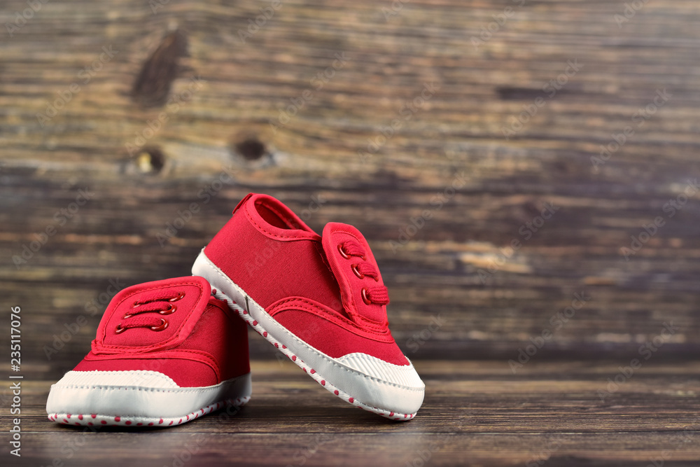 Håndbog dvs. flamme A pair of red baby boy shoes/sneakers on dark wooden background, kid's  clothes concept, traveling with kids concept, children lifestyle, parenting  concept Stock Photo | Adobe Stock