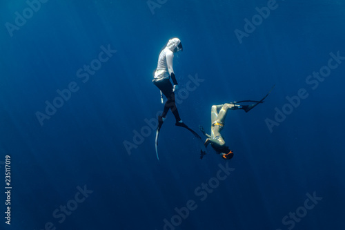 Two female free divers seen playing underwater