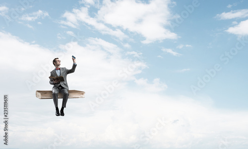 Wallpaper Mural Young businessman or student floating in blue sky and studying the science Torontodigital.ca