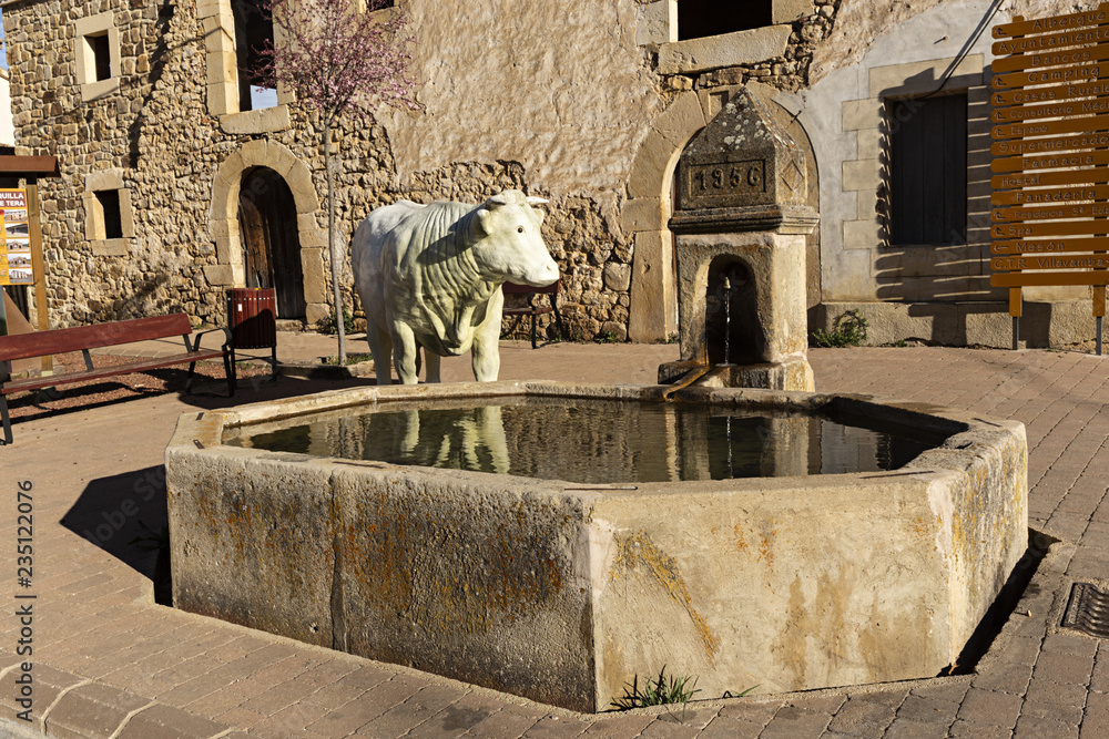 Fuente y escultura de vaca.
