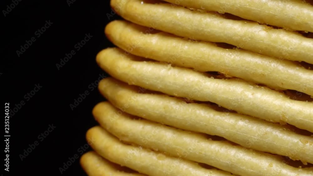 Stack of square crackers on a black background in rotation. Crackers spin. Stack of square crackers on a black background in rotation. Crackers spin.