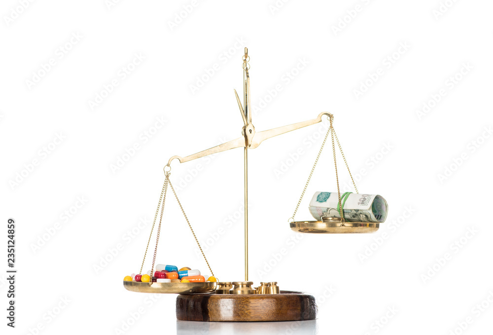 scales with various colorful pills and russian cash money isolated on white