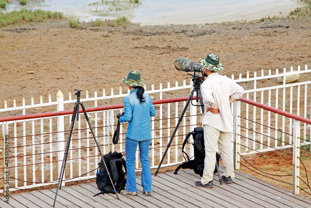 A man and a woman two photographers were photographing in a wetland park, china A man and a woman two photographers were photographing in a wetland park, china