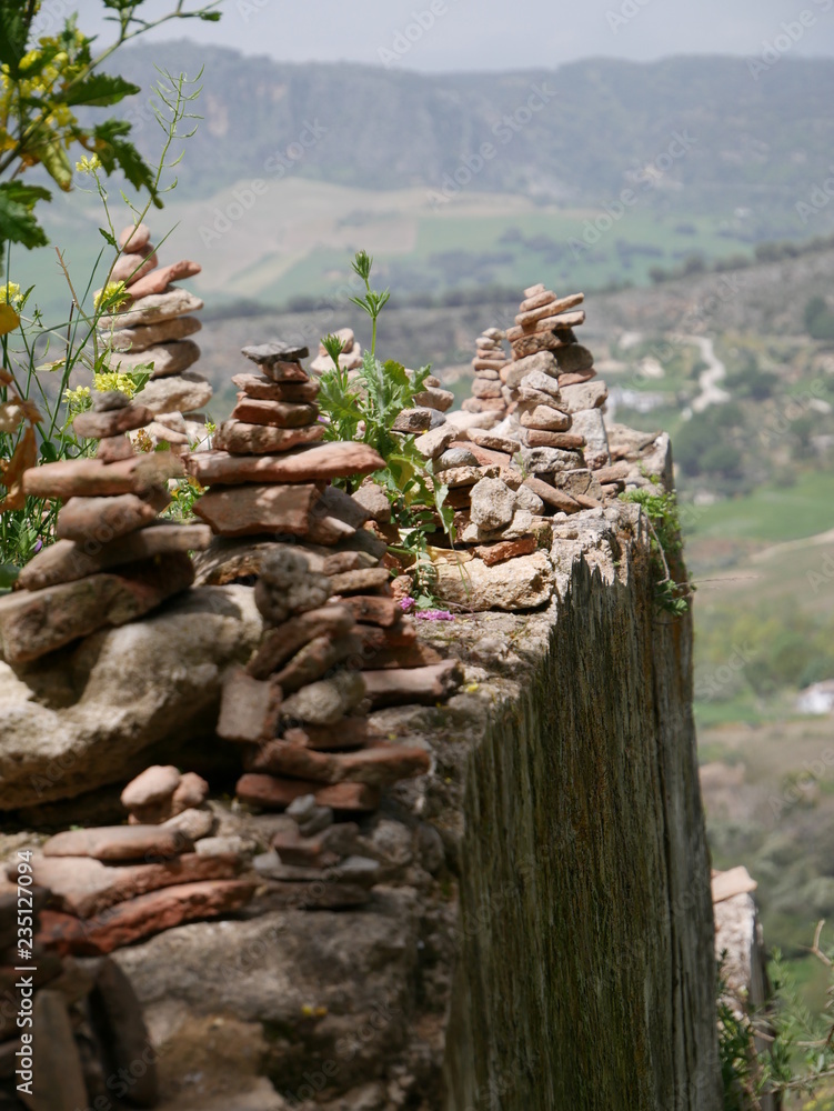 Pile of orange stones in perfect balance on a cliff in the mountains of Ronda, Spain Pile of orange stones in perfect balance on a cliff in the mountains of Ronda, Spain