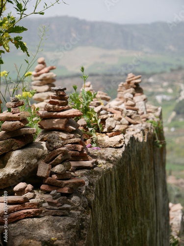 Pile of orange stones in perfect balance on a cliff in the mountains of Ronda, Spain